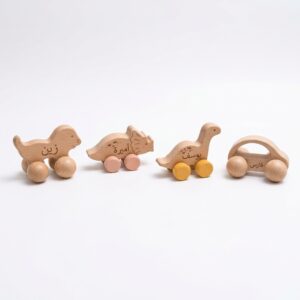 Four personalized gugu wooden push toys, three dinosaurs and a car, engraved with the Arabic names Zain, Amira, Yousef and Fares.